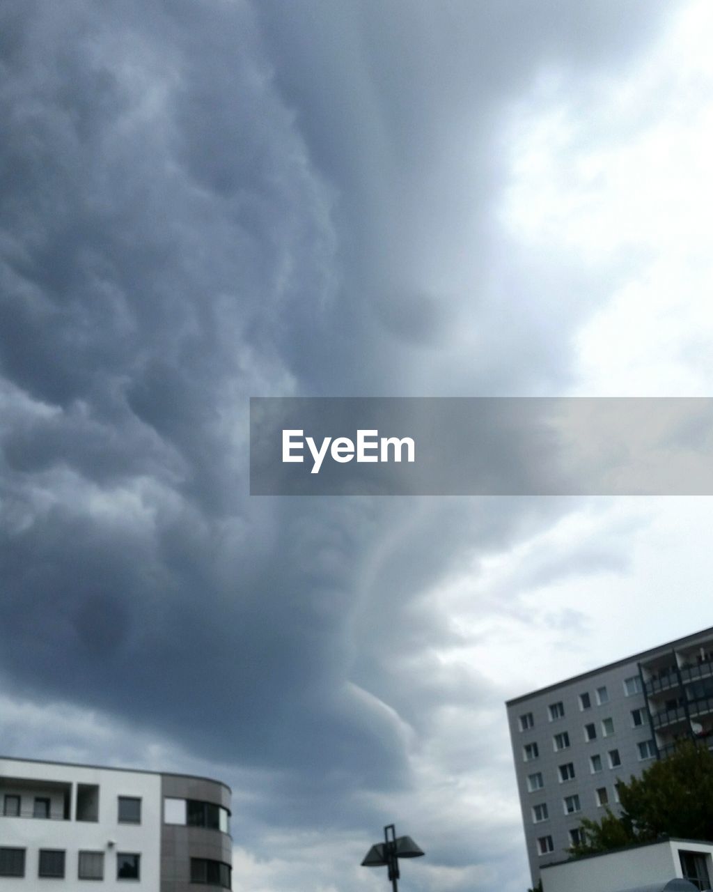 VIEW OF BUILDINGS IN CITY AGAINST CLOUDY SKY