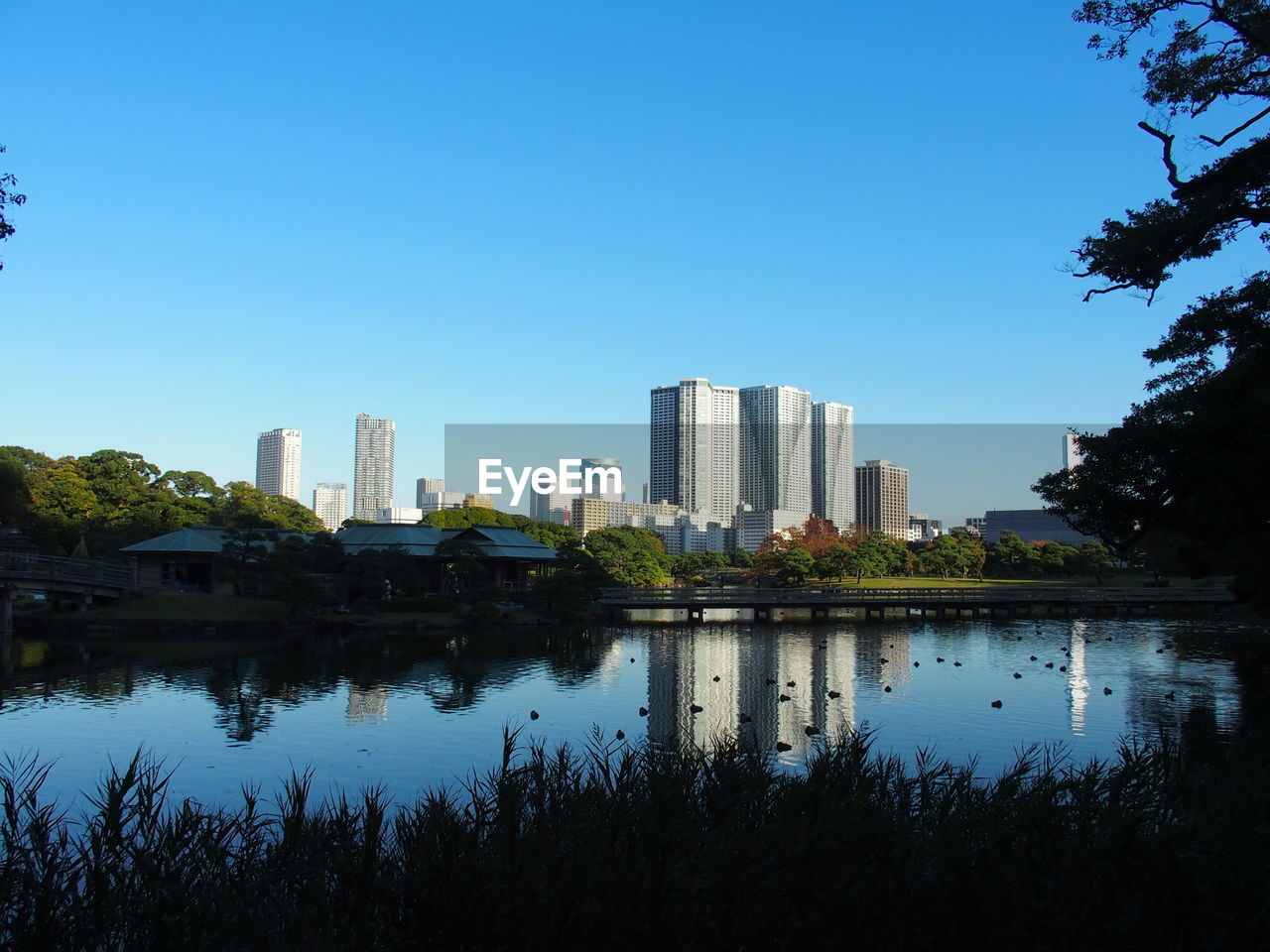 LAKE AND BUILDINGS AGAINST BLUE SKY