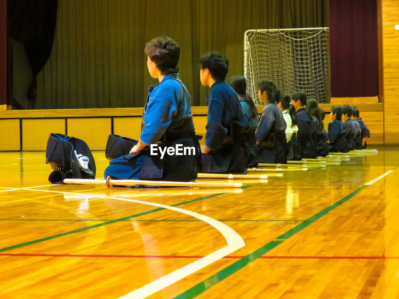 Martial art student sitting in row learning principles of self defence art