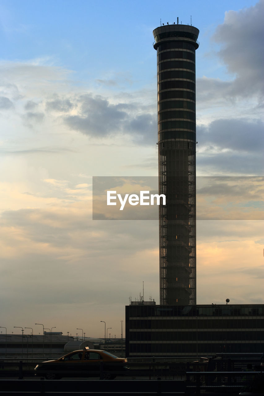 LOW ANGLE VIEW OF ILLUMINATED BUILDING AGAINST SKY DURING SUNSET