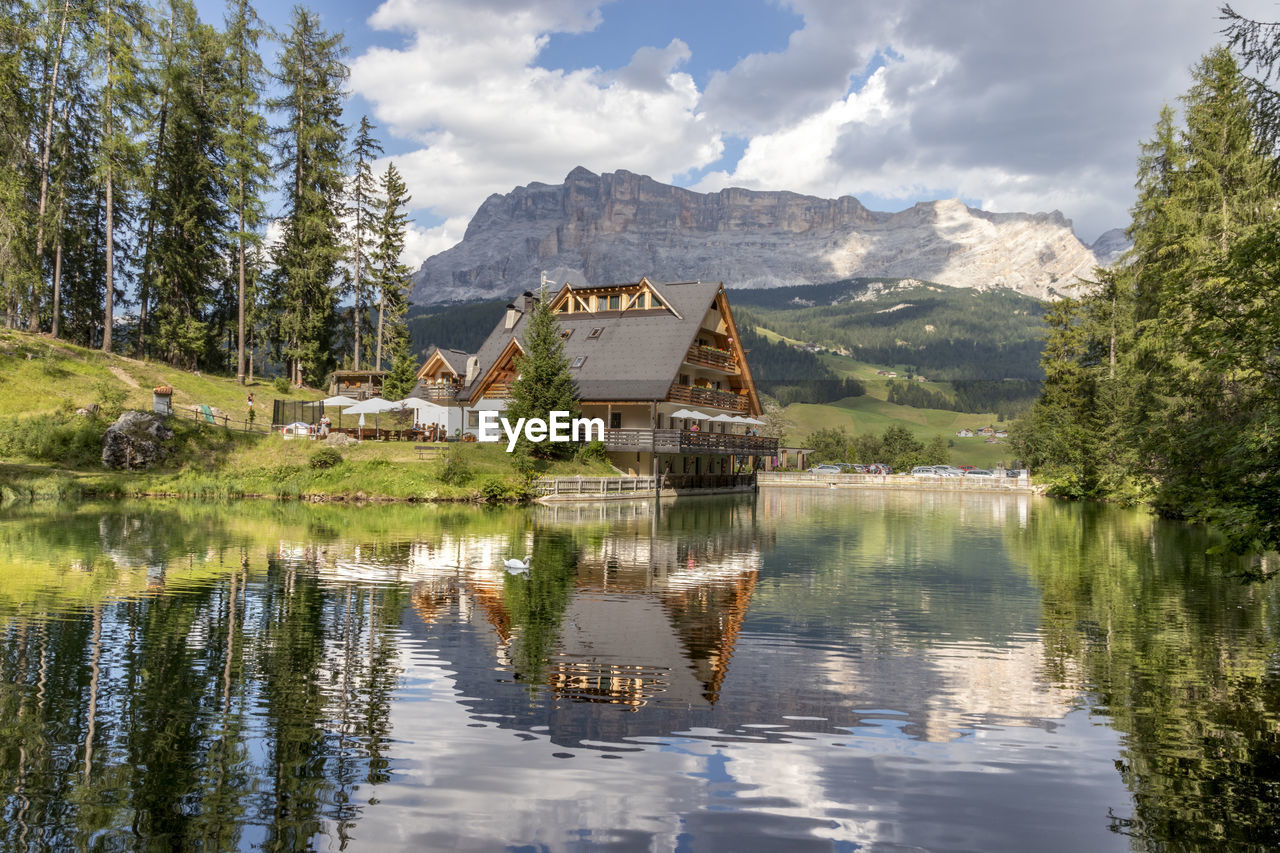 Houses by lake against sky