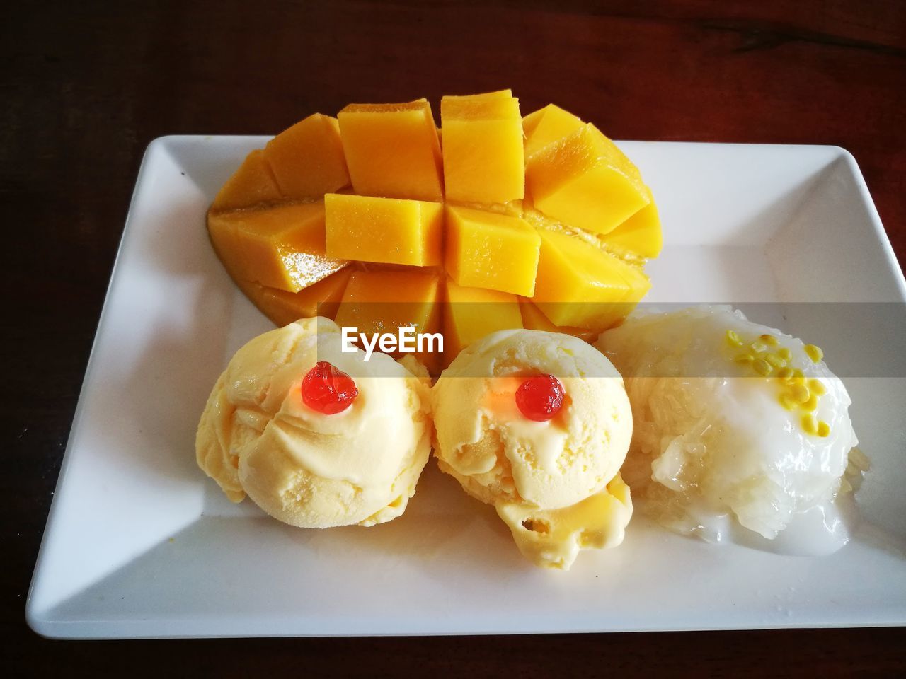 High angle view of dessert and mango fruit in plate on table