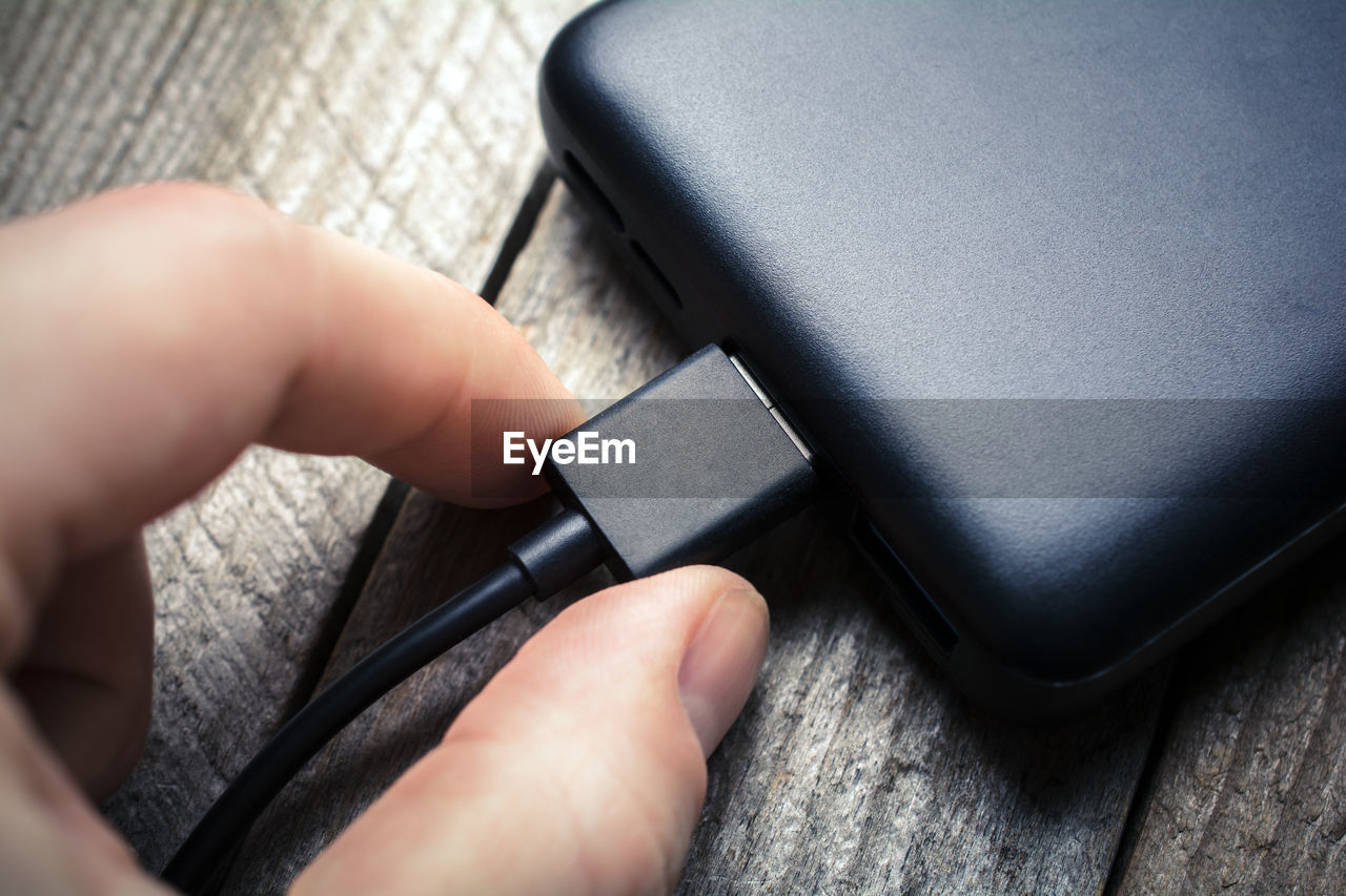 HIGH ANGLE VIEW OF PERSON HAND HOLDING CAMERA ON MIRROR