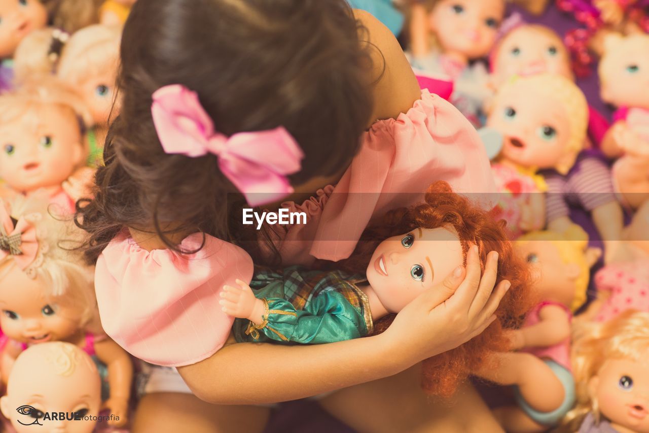 Close-up of girl playing with dolls at home