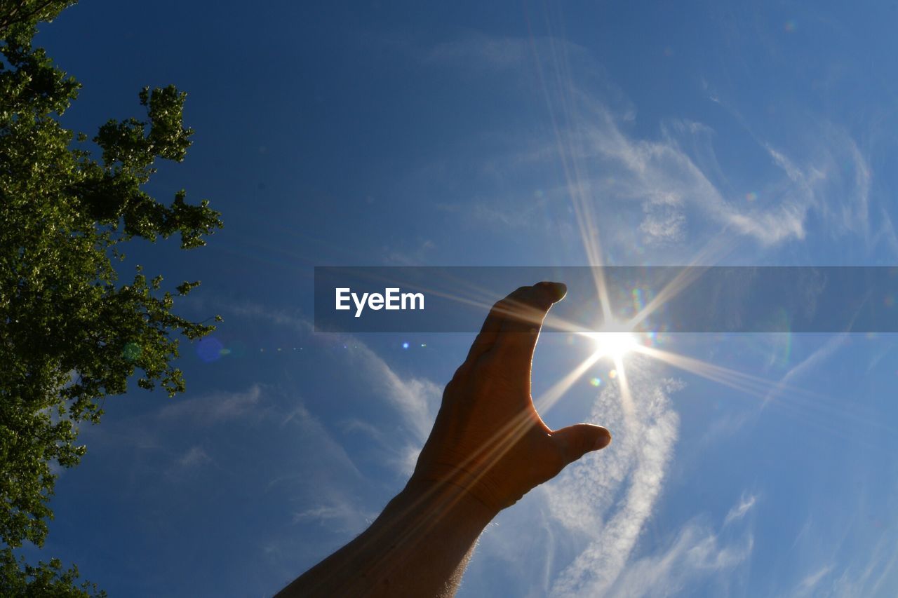 Human hand reaching for sun