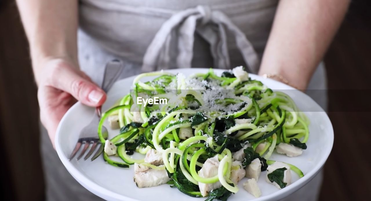 Midsection of woman holding salad