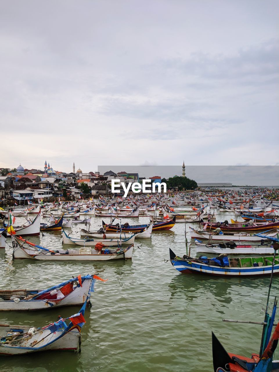 Boats moored in river against buildings in city