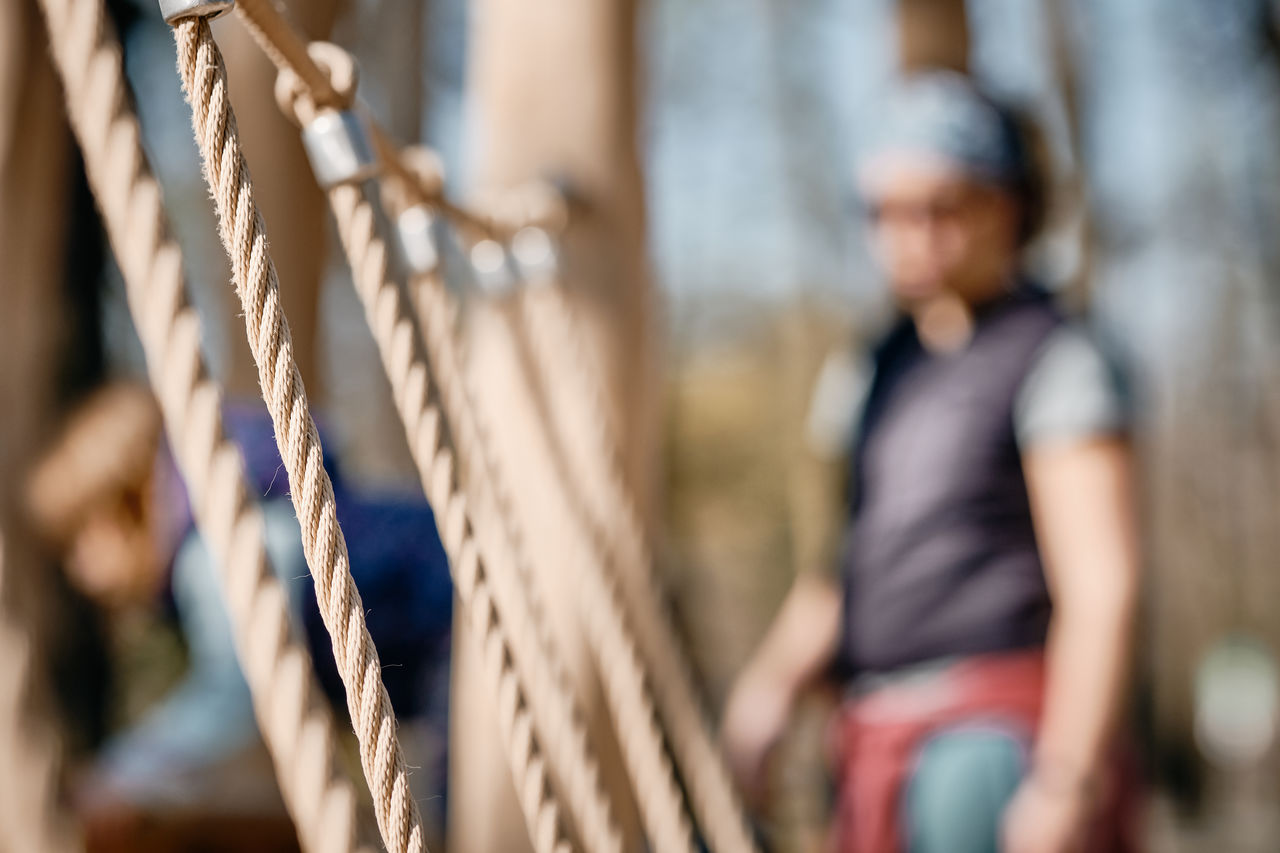 Close-up of rope with woman standing in background