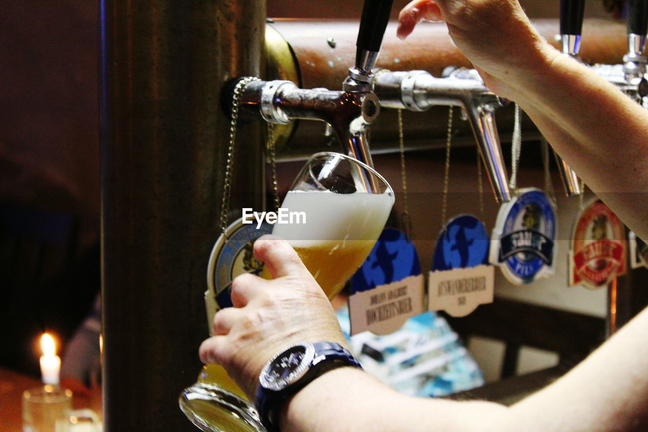 CLOSE-UP OF HAND HOLDING GLASS OF DRINK