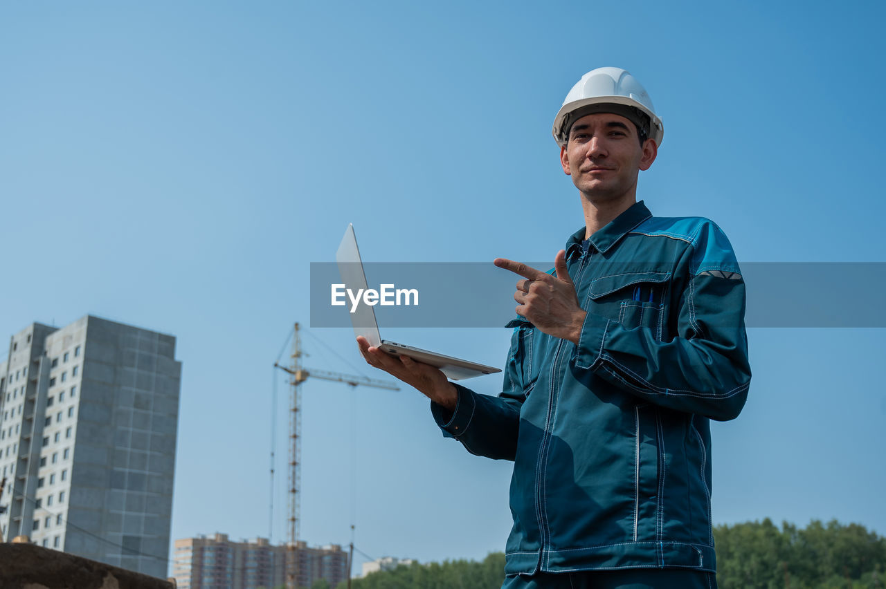 portrait of young man standing against clear sky