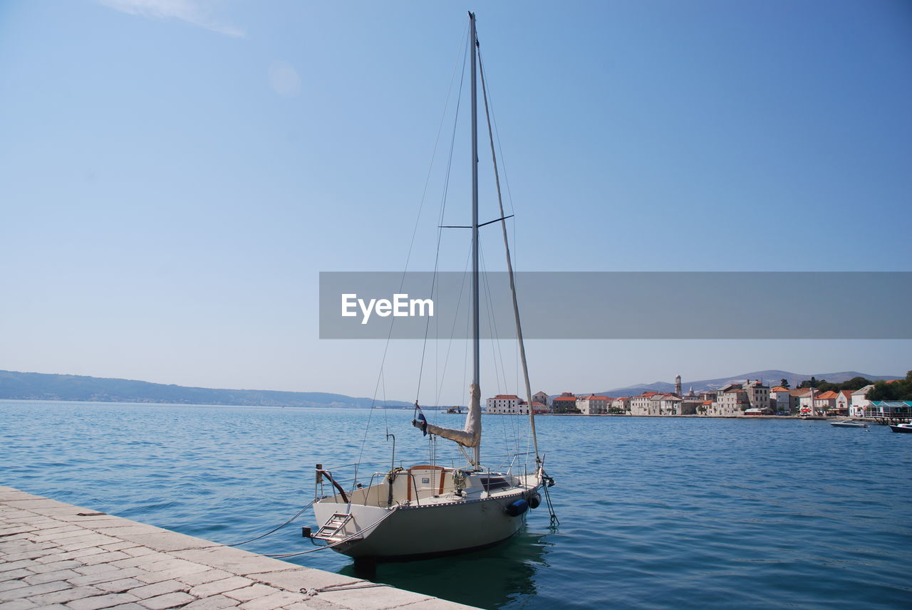 Sailboat sailing on sea against clear sky