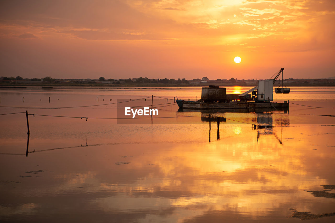 Scenic view of sea against orange sky. 