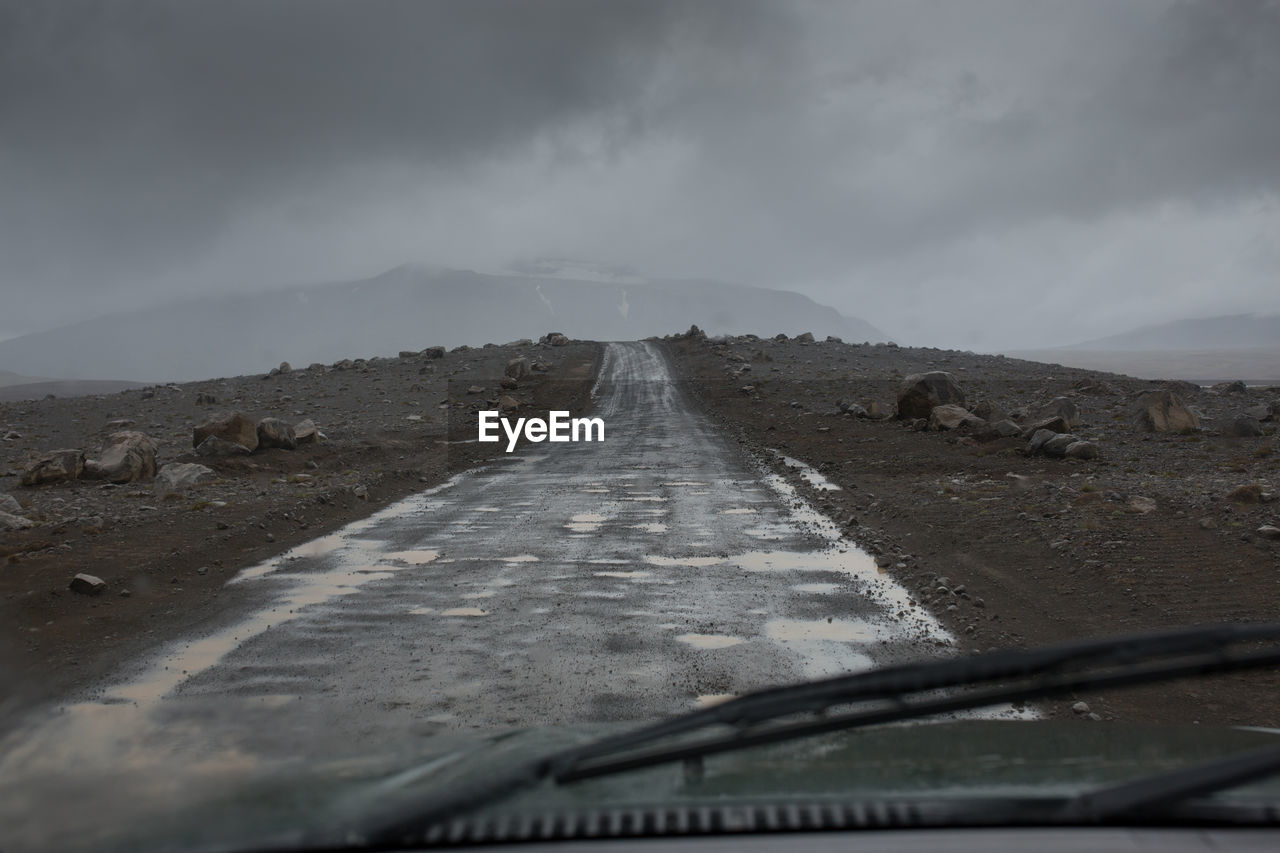 Mountain road against overcast sky