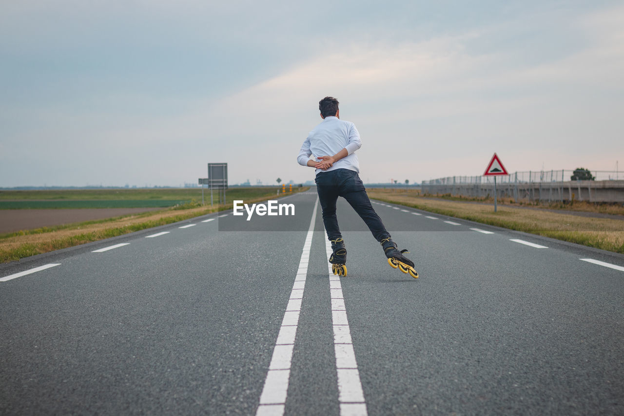 rear view of woman walking on road