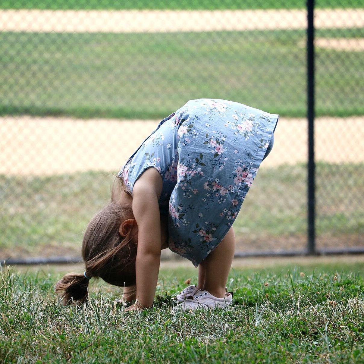 LOW SECTION OF WOMAN STANDING ON GRASSY FIELD