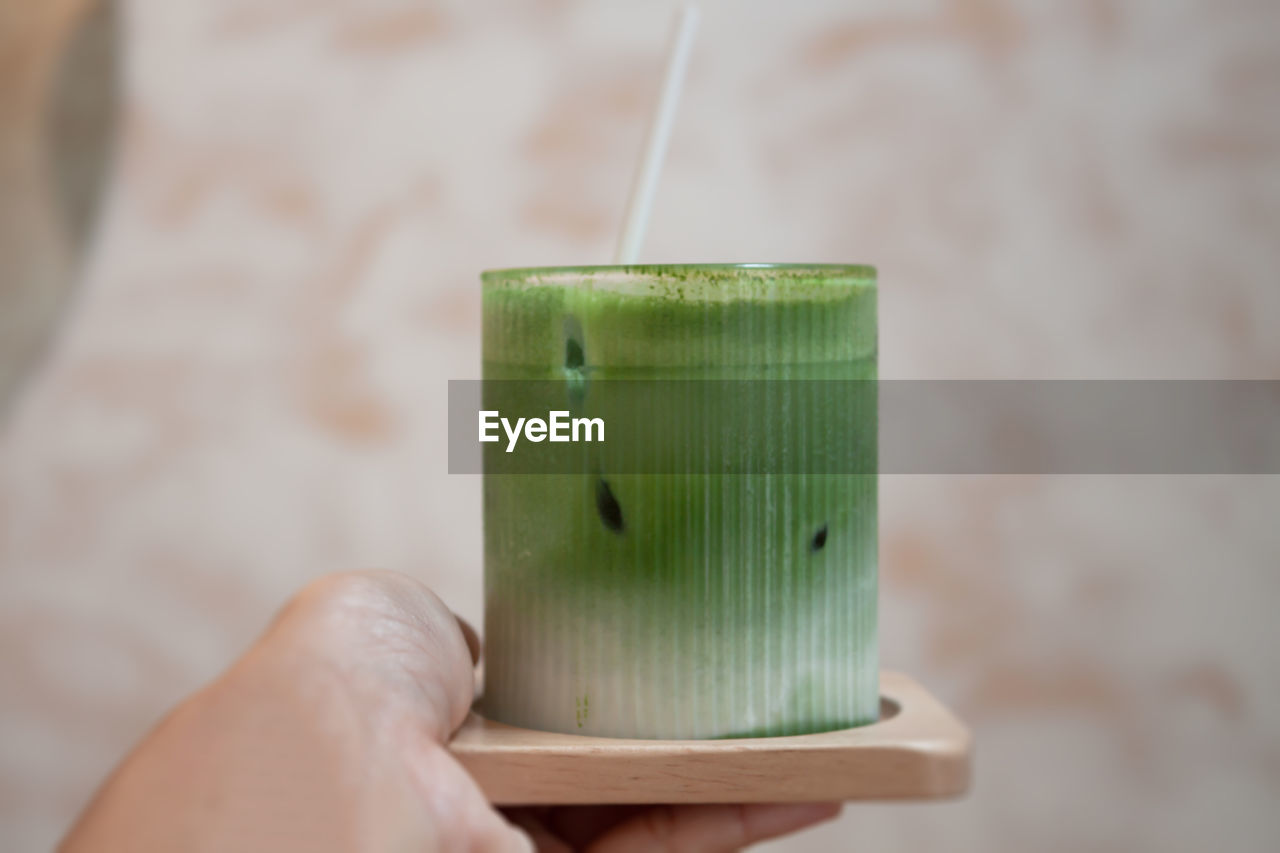 green, hand, holding, lighting, focus on foreground, food and drink, one person, close-up, indoors, healthy eating, drink, wellbeing, food, refreshment, freshness, produce, adult, fruit, lifestyles, drinking straw, household equipment, drinking glass, day