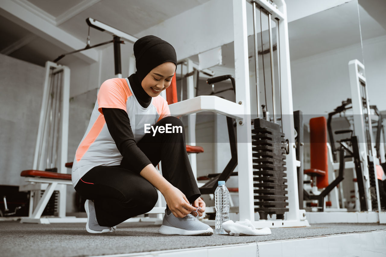 side view of woman exercising in gym