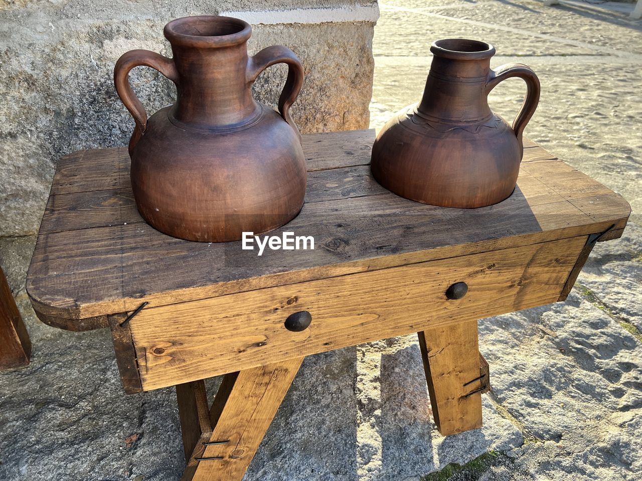 Close-up clay pots on top of wooden stand