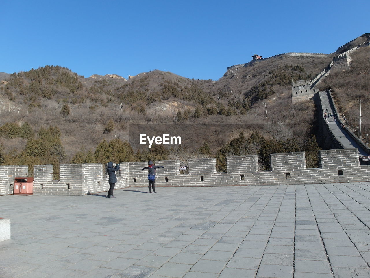 Woman photographing daughter at great wall of china