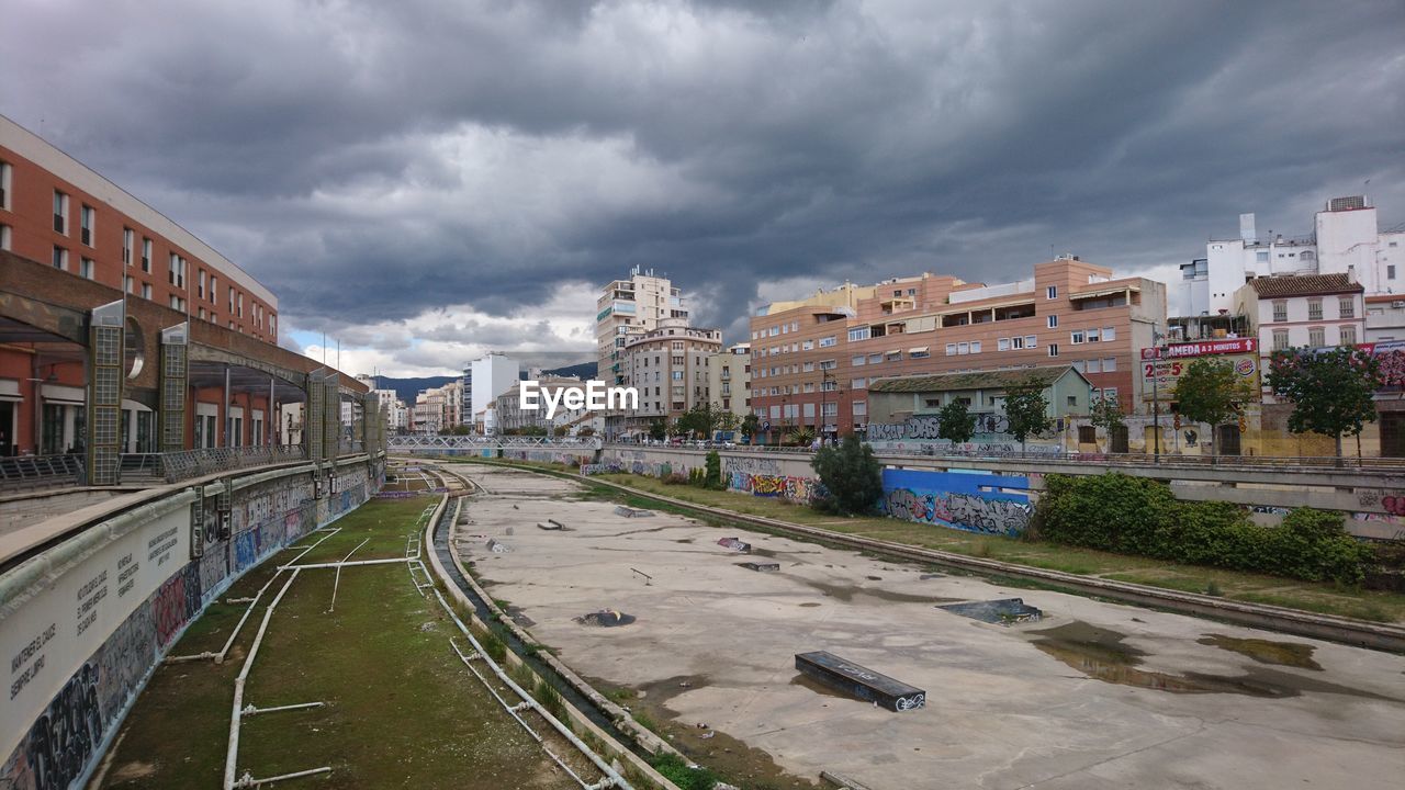 Road amidst buildings in city against sky