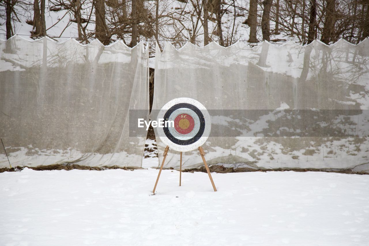 Dartboard on snow covered field