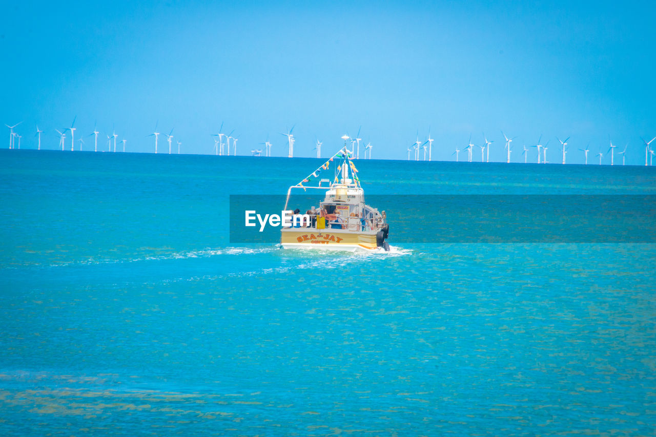 SHIP SAILING IN SEA AGAINST BLUE SKY