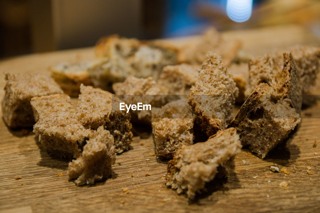 CLOSE-UP OF BREAD ON WOOD