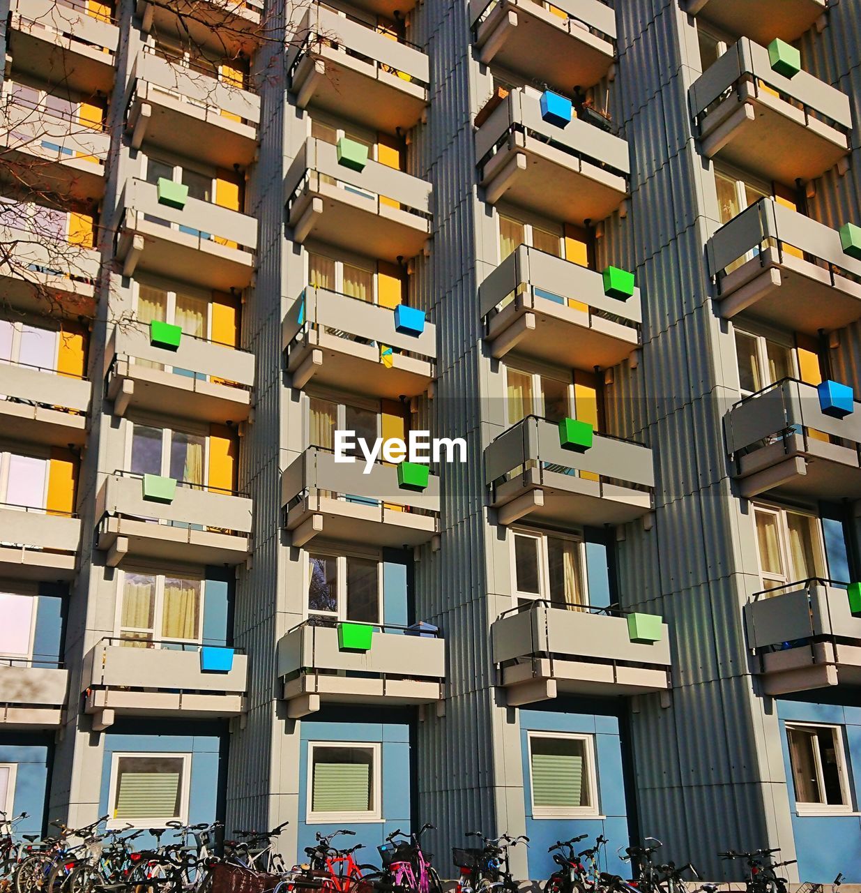 architecture, building exterior, built structure, building, neighbourhood, city, residential area, urban area, crowd, facade, tower block, group of people, condominium, residential district, window, day, outdoors, in a row, metropolis, lifestyles, nature, apartment, large group of people, downtown, sunlight, low angle view