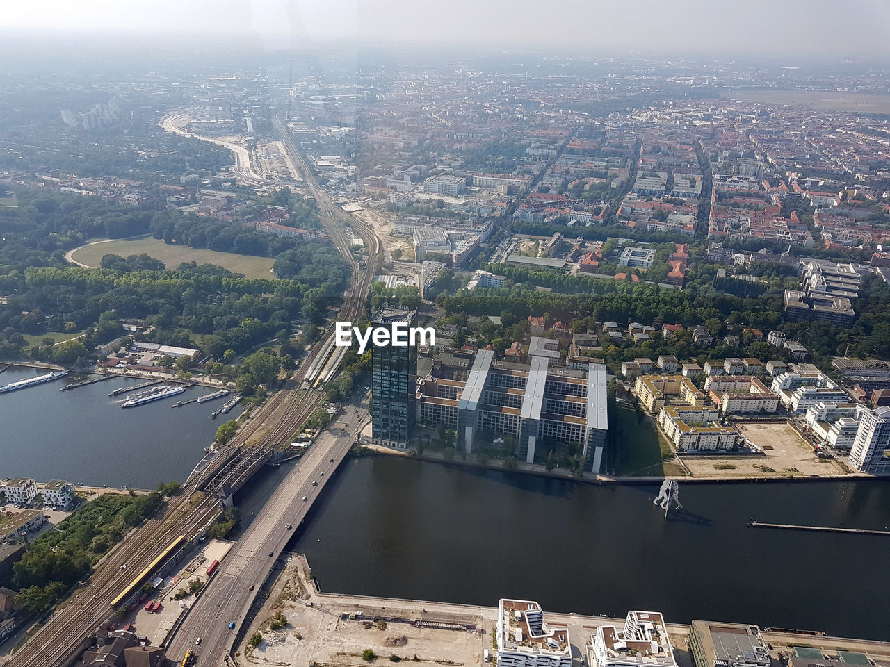 HIGH ANGLE VIEW OF RIVER AMIDST BUILDINGS AGAINST SKY