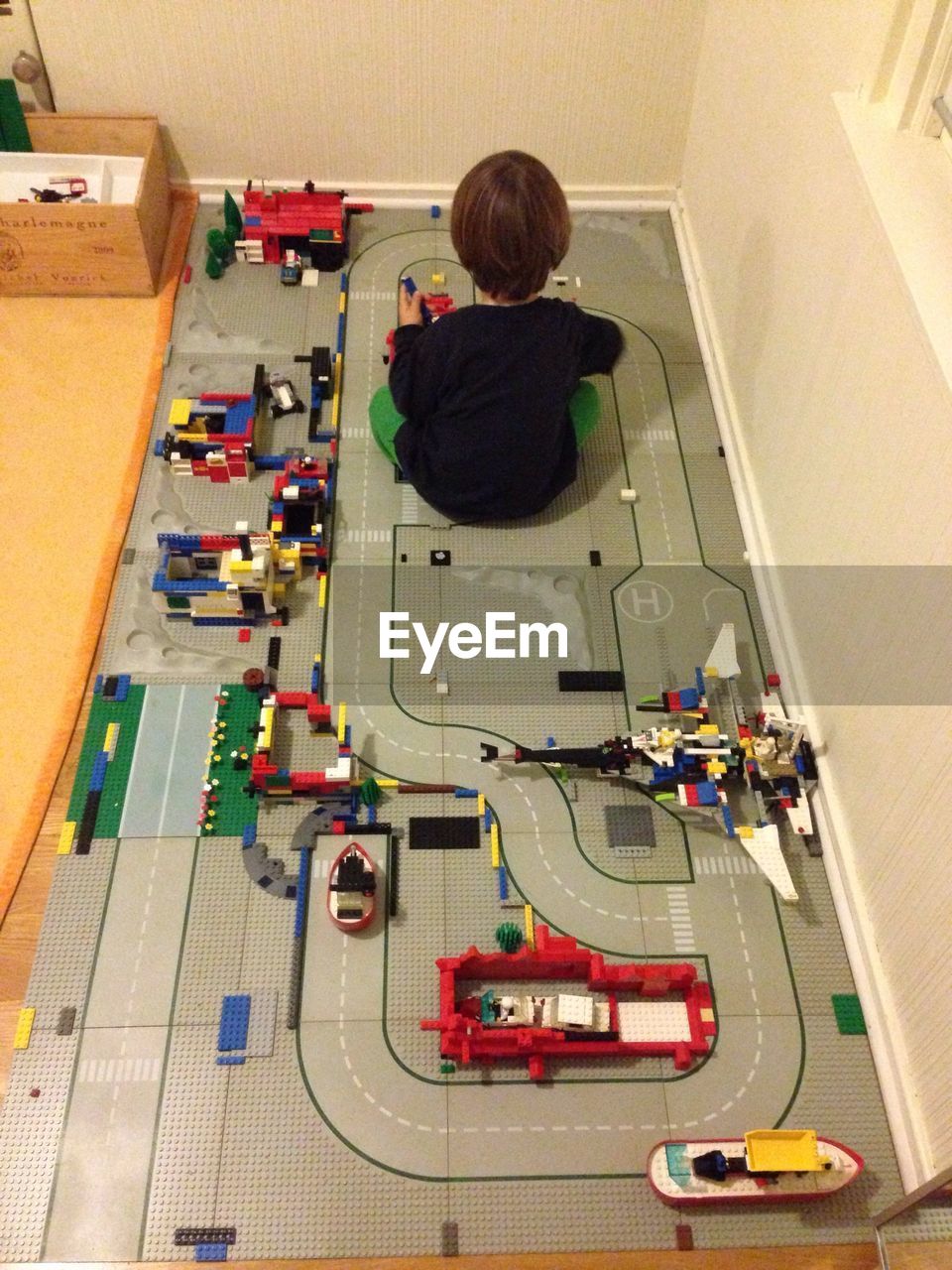 Rear view of boy sitting with toys at home