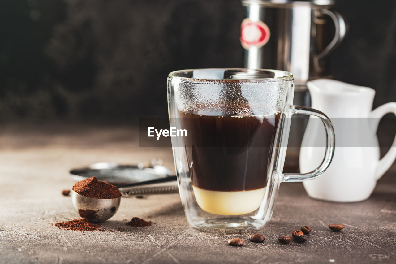 CLOSE-UP OF COFFEE CUP AND TABLE