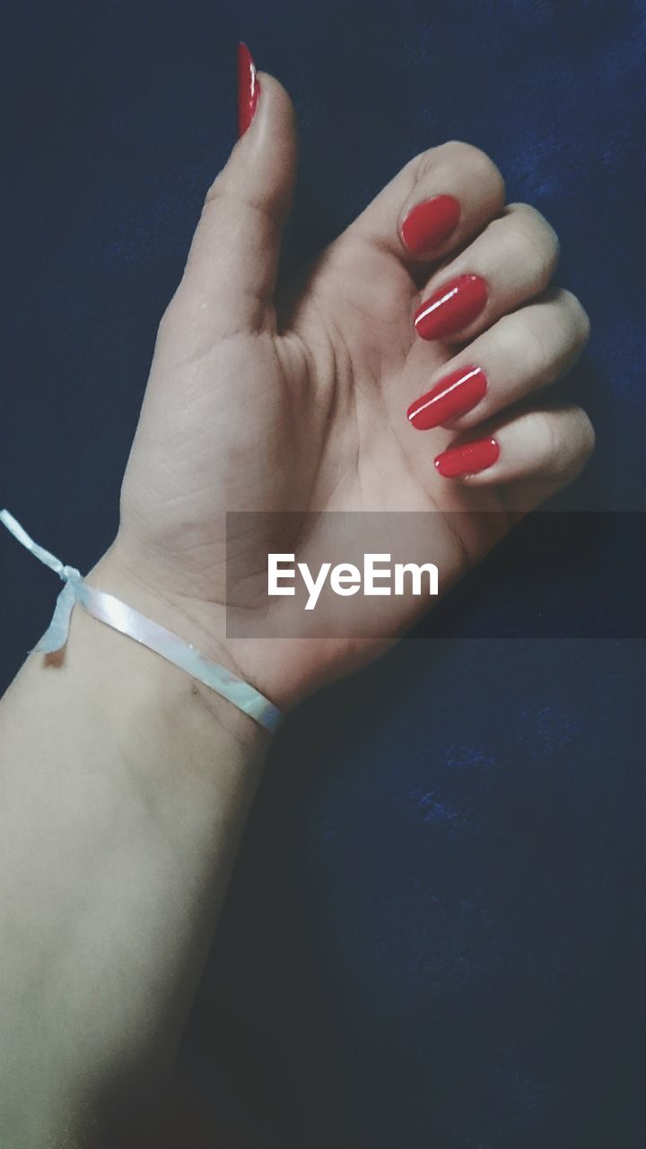 Close-up of woman's hand with red nail polished