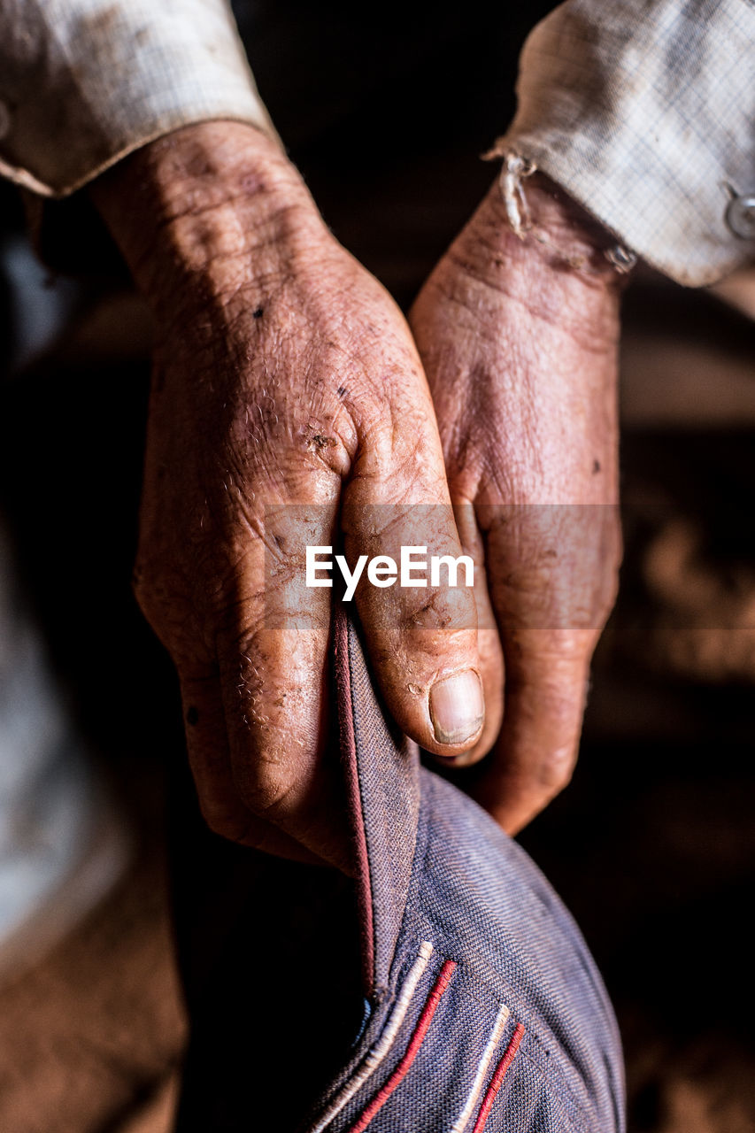 Cropped hands of man holding cap