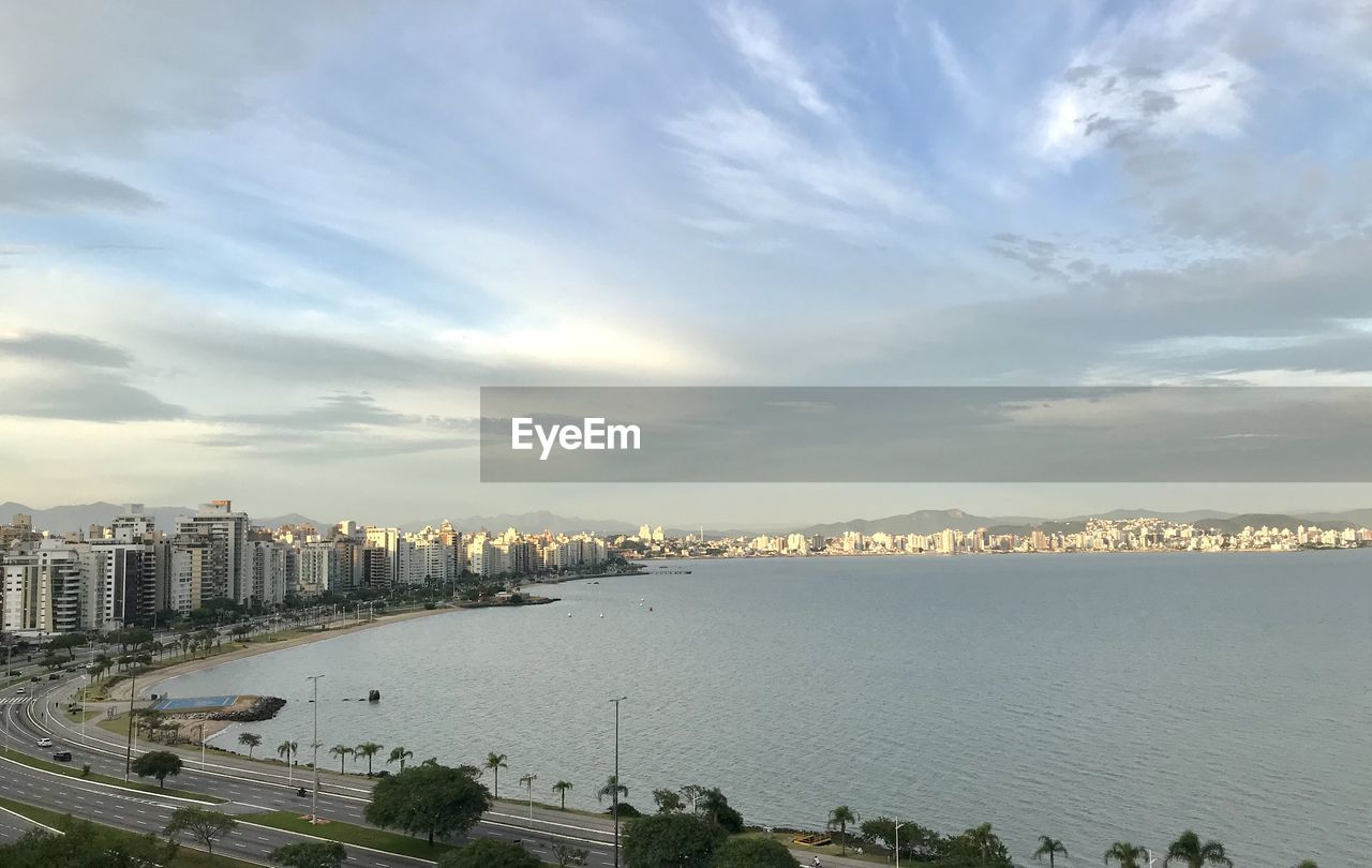 HIGH ANGLE VIEW OF BAY AND BUILDINGS AGAINST SKY