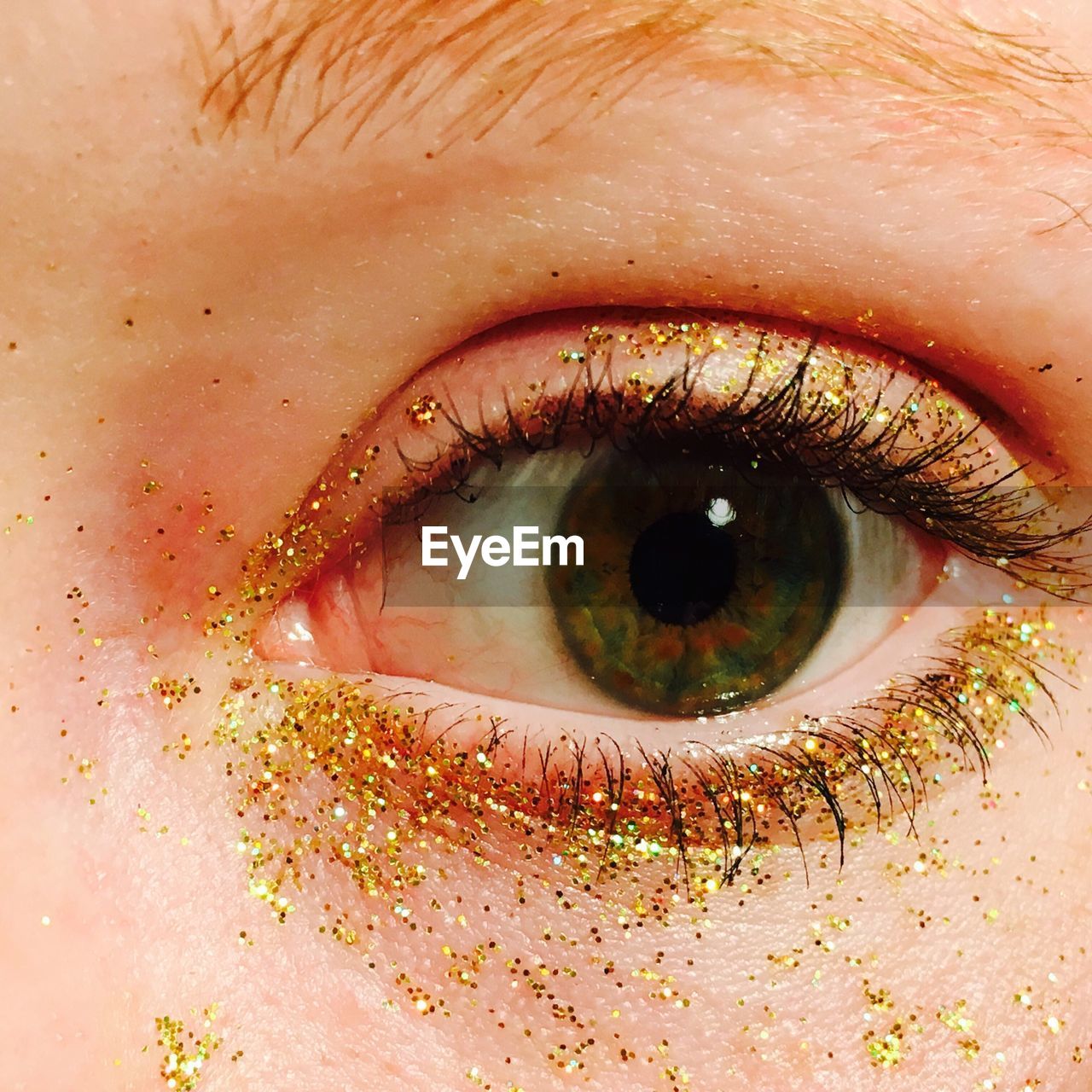 Cropped image of woman eye with glitters