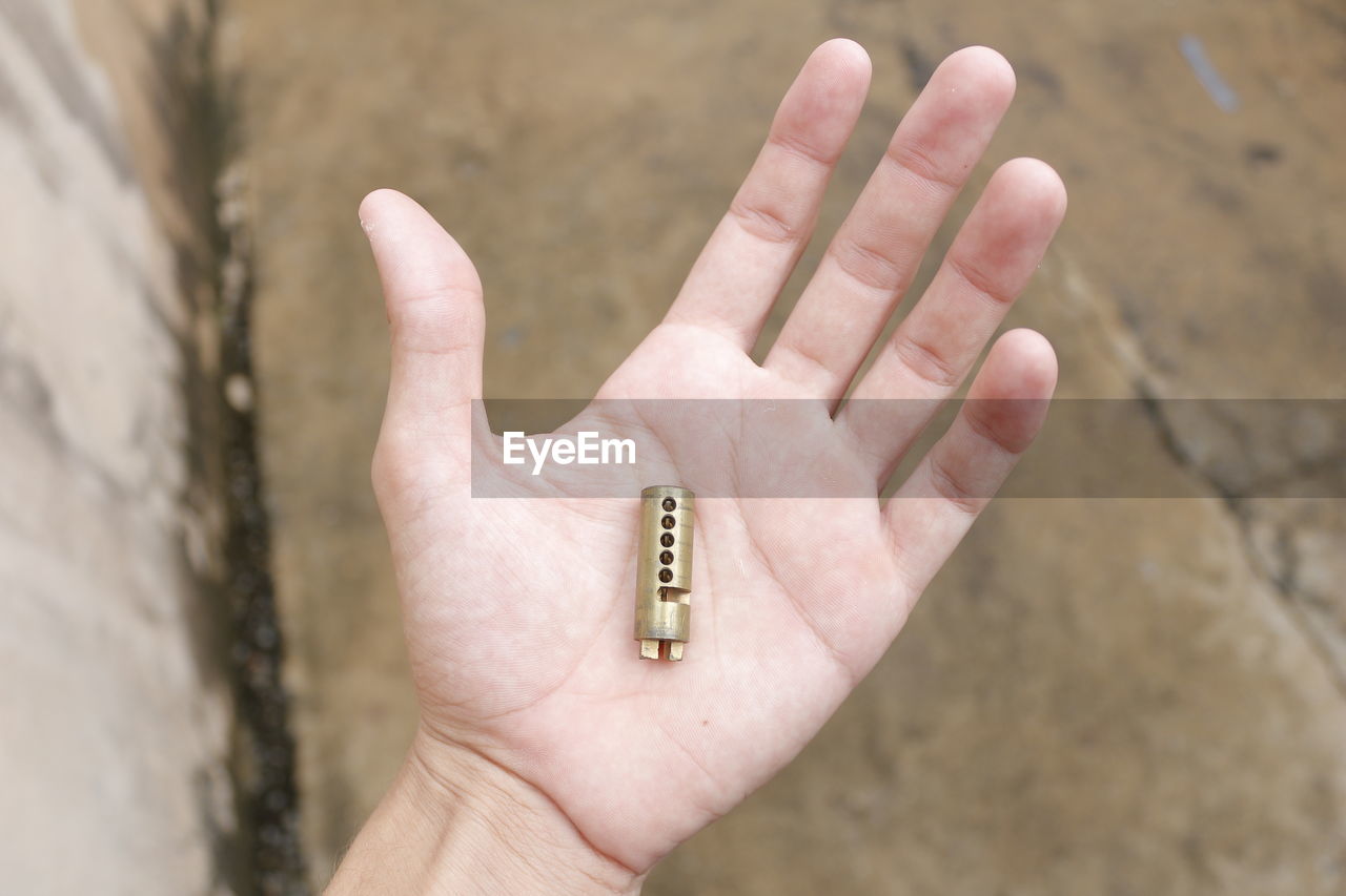 Cropped image of hand holding broken lock