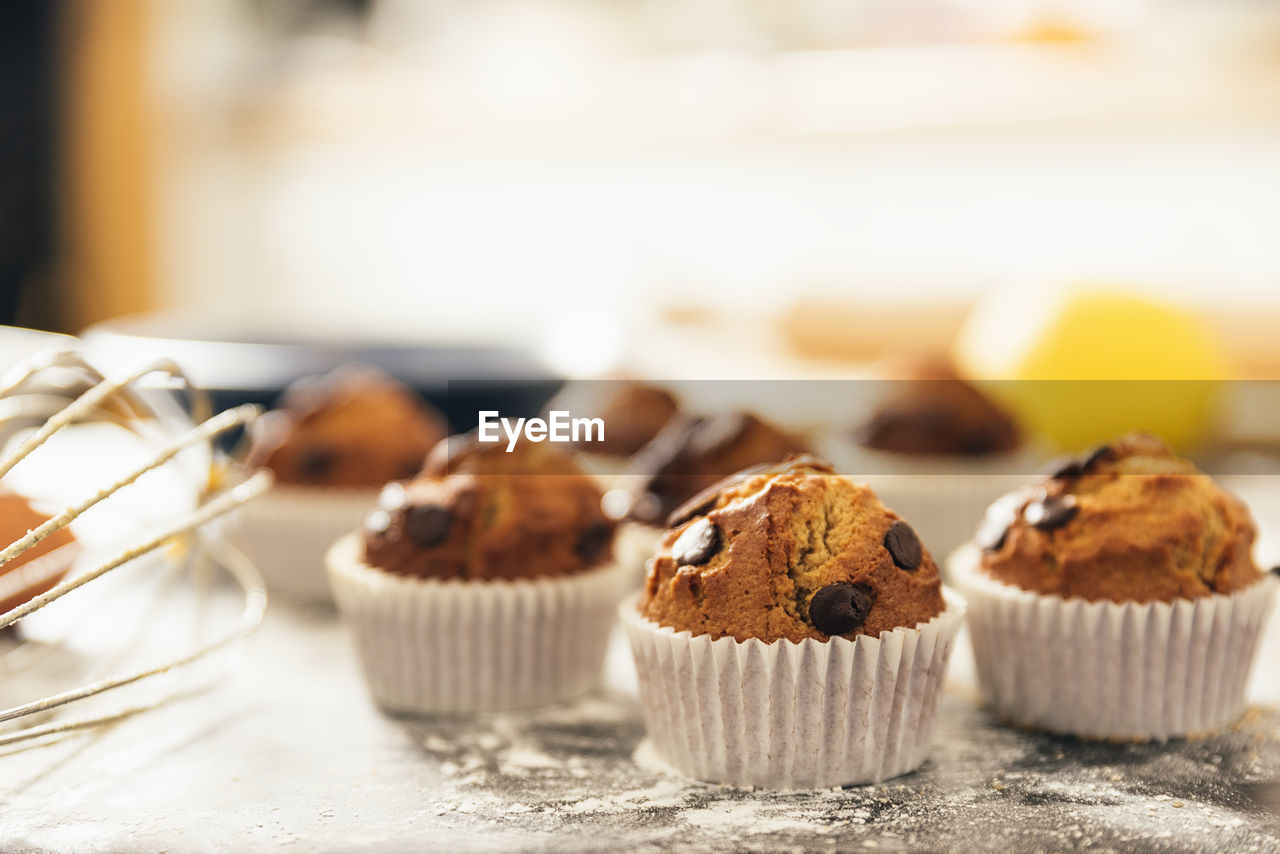 CLOSE-UP OF CUPCAKES ON TABLE AGAINST WALL