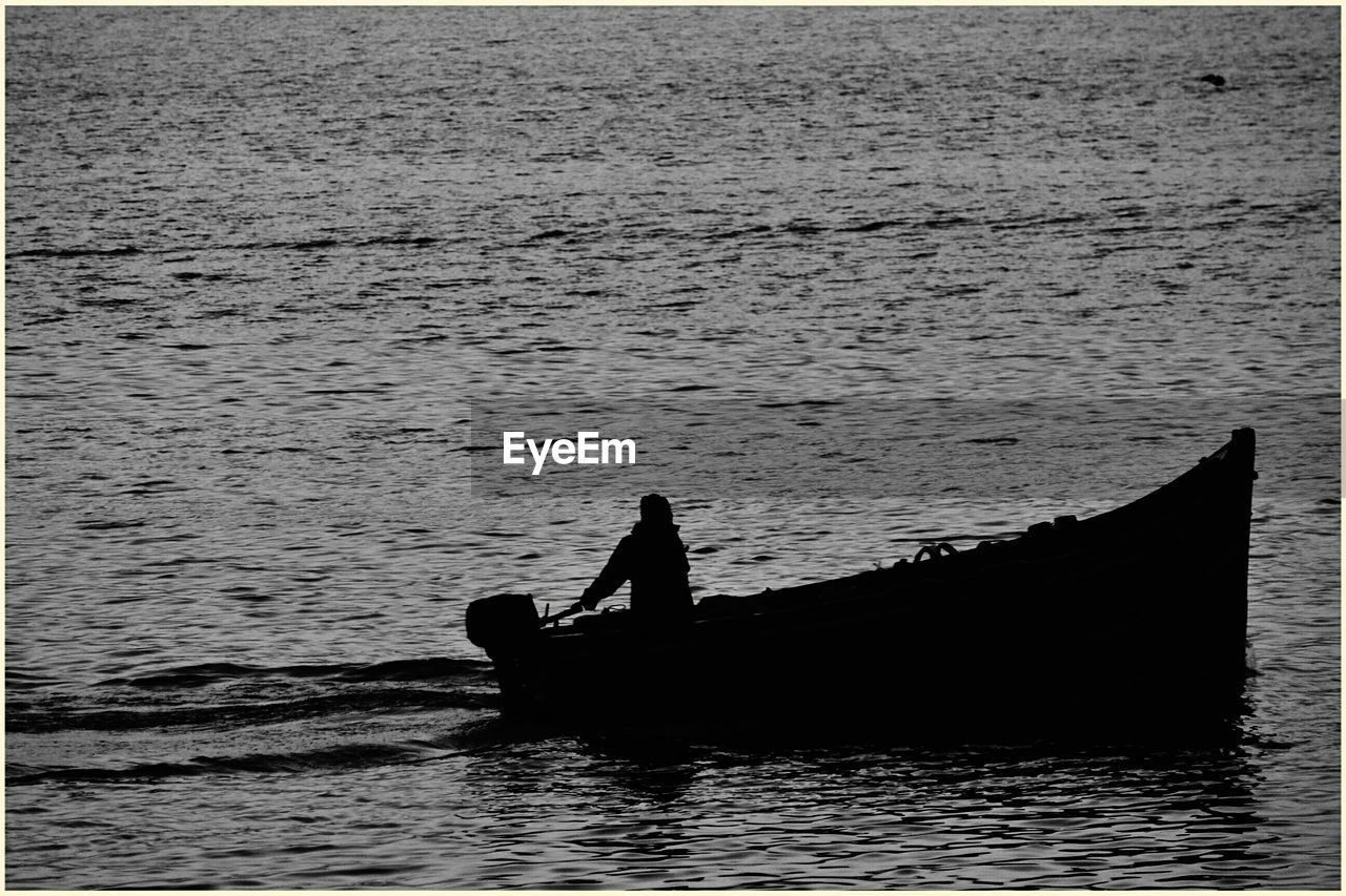 Silhouette of person boating in sea