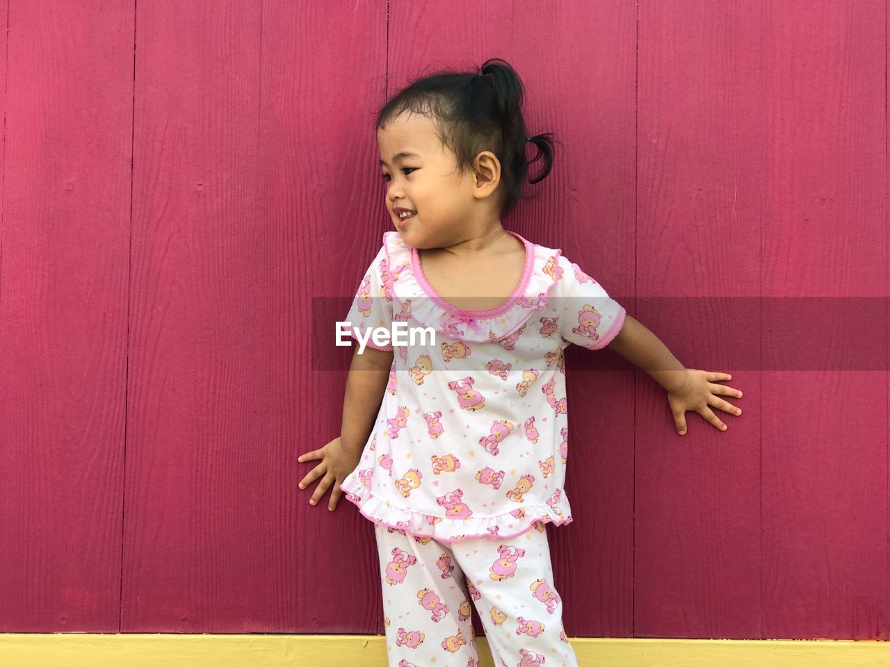 Cute girl standing against wall