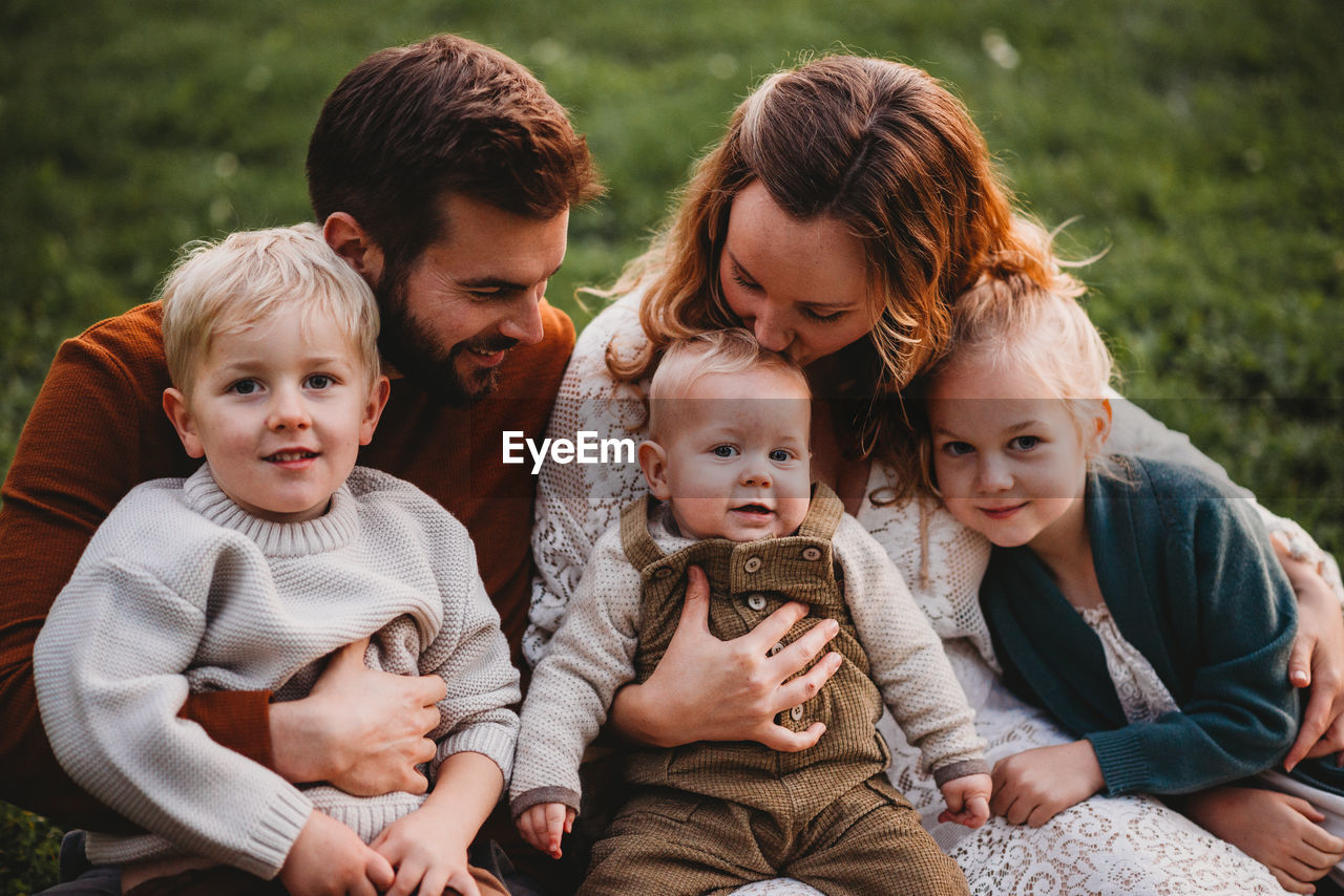 Beautiful family sitting in a park on a fall day