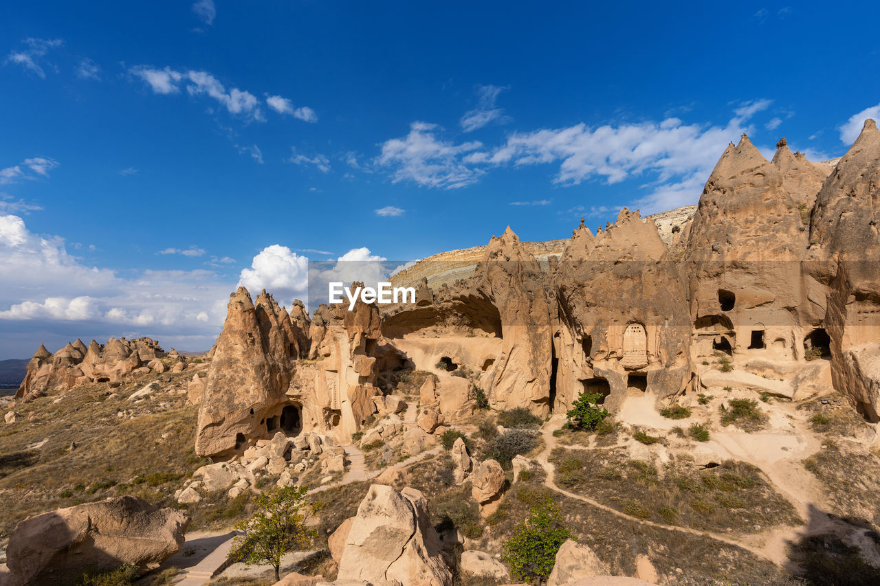 ROCK FORMATIONS ON MOUNTAIN AGAINST CLOUDY SKY