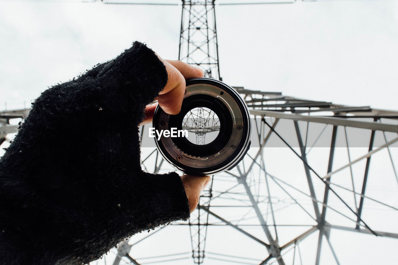 Low angle view of electricity pylon seen through lens against sky