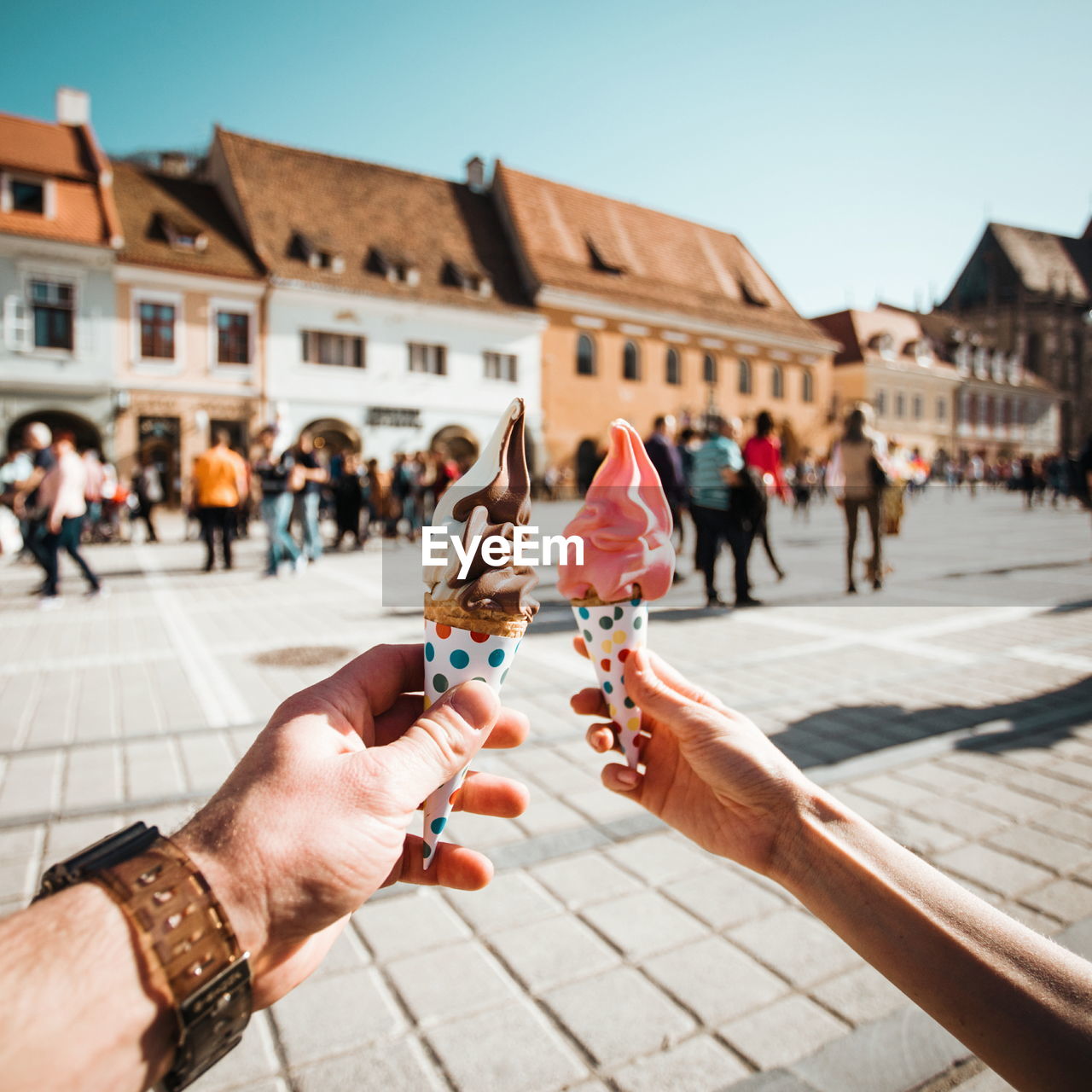 People holding ice cream in city