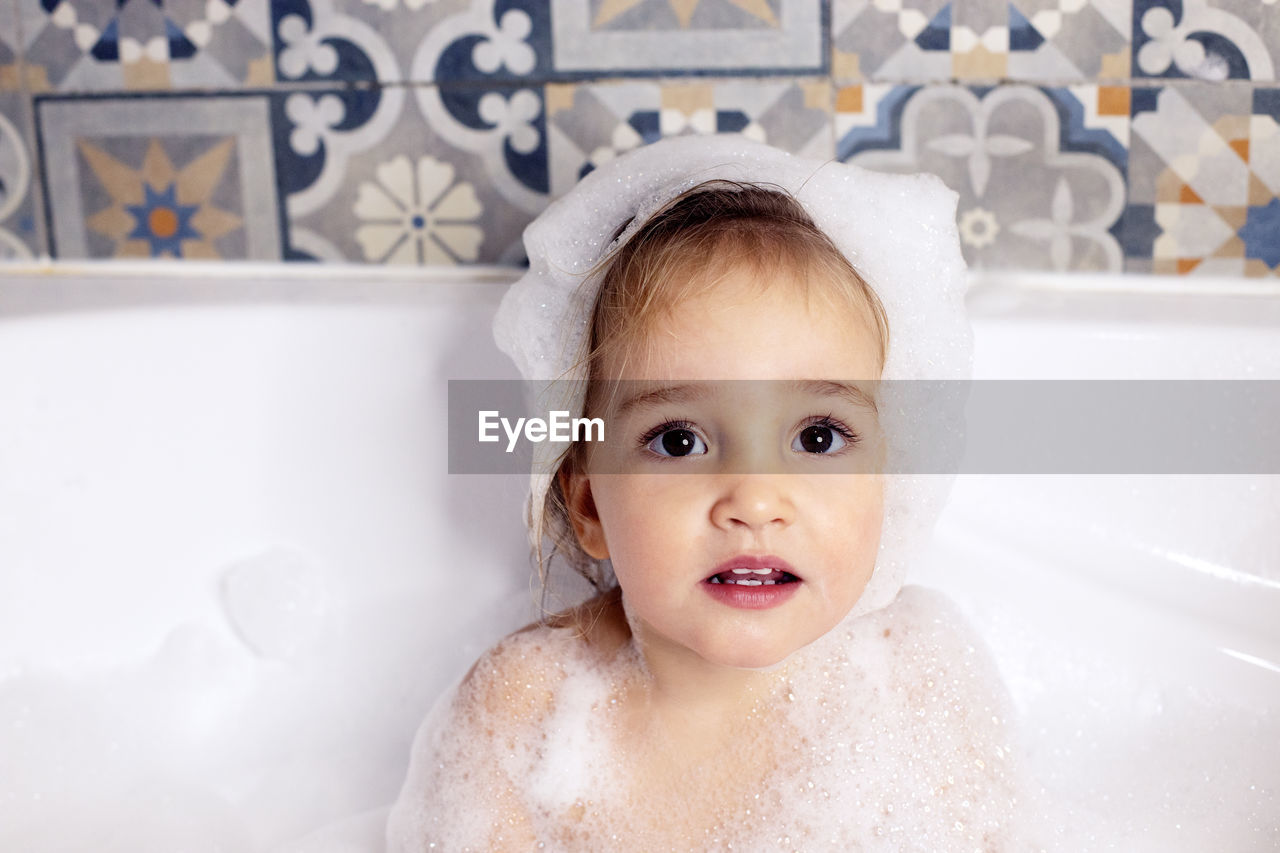 Cute girl sitting in bath tub