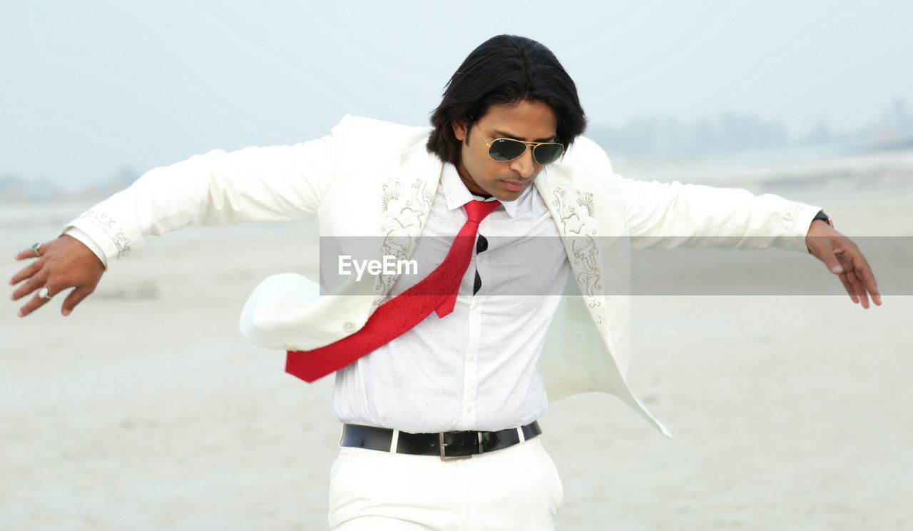 Man wearing white suit on the beach