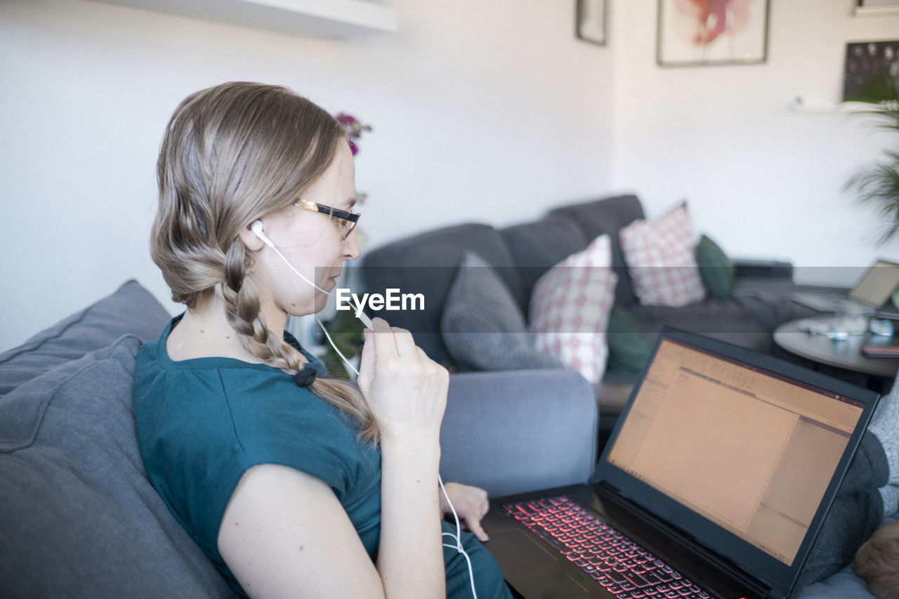 Woman in living room using laptop