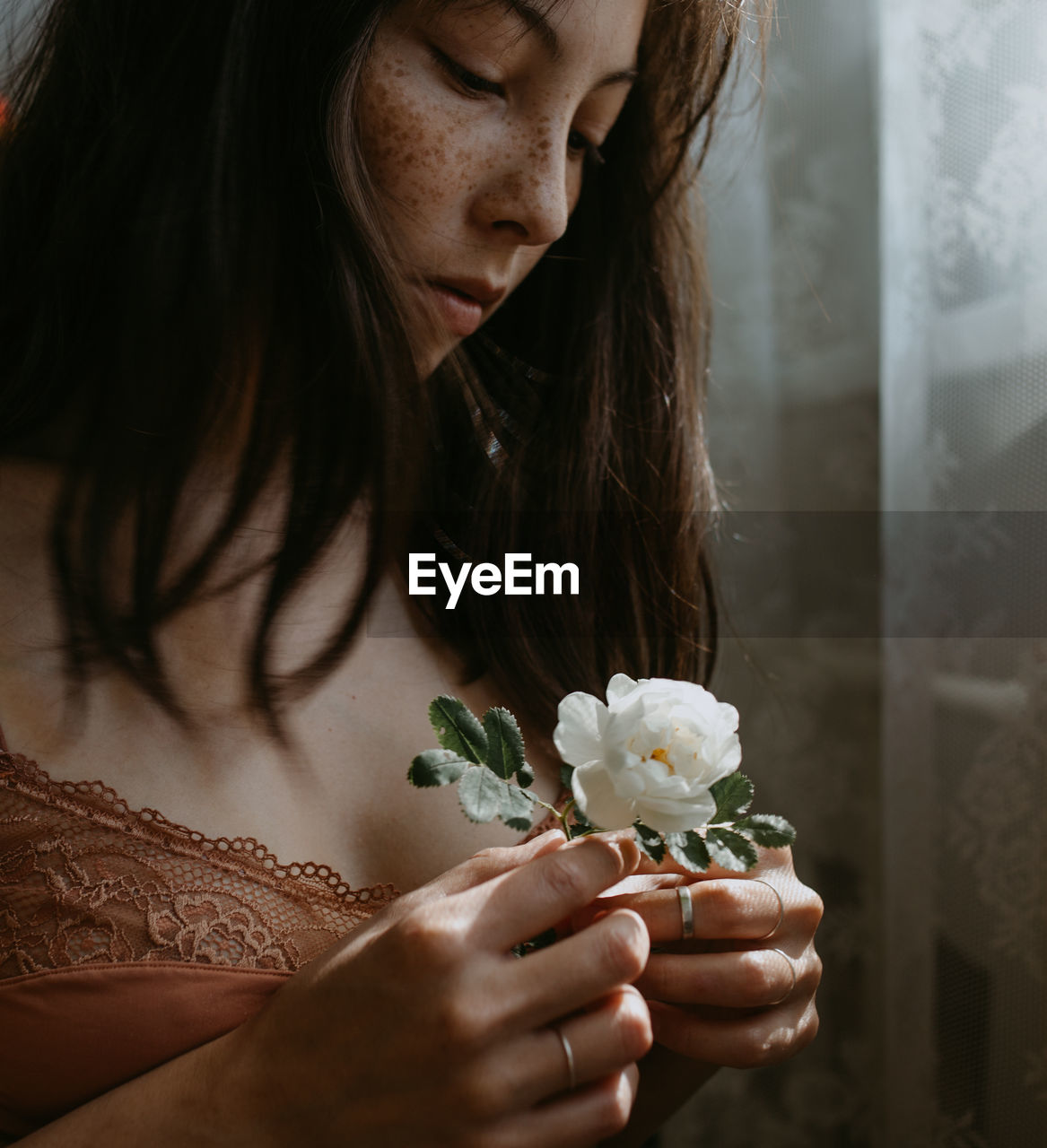 Close-up of young woman holding dog rose