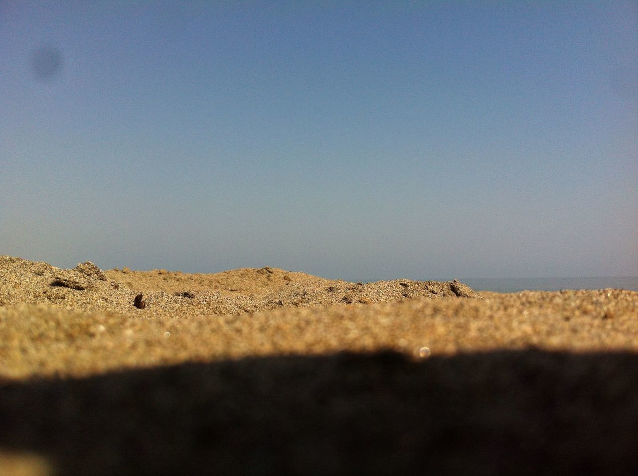 SCENIC VIEW OF SAND DUNES AGAINST CLEAR SKY