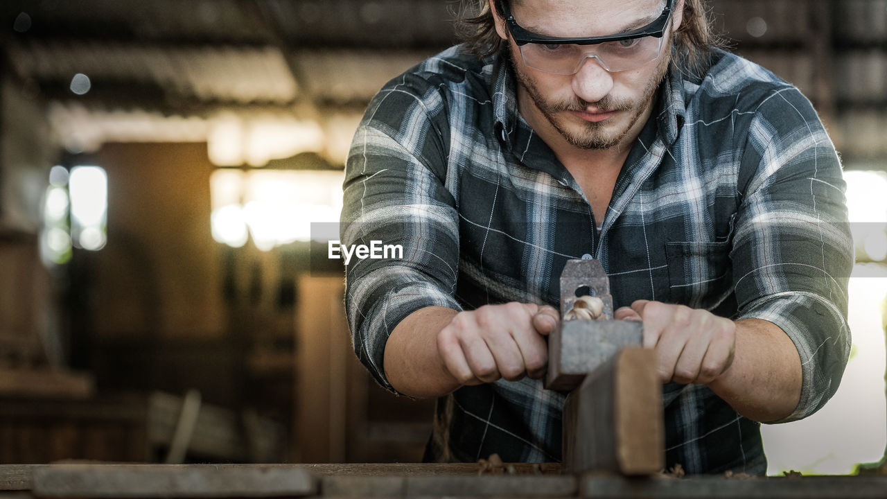 MIDSECTION OF MAN WORKING WITH ARMS RAISED