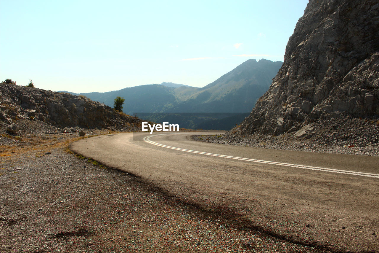 Empty road by mountains against sky